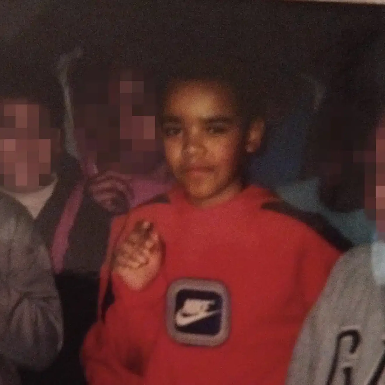 a childhood image of Alex Augustin, a young Black boy wearing a red nike jumper